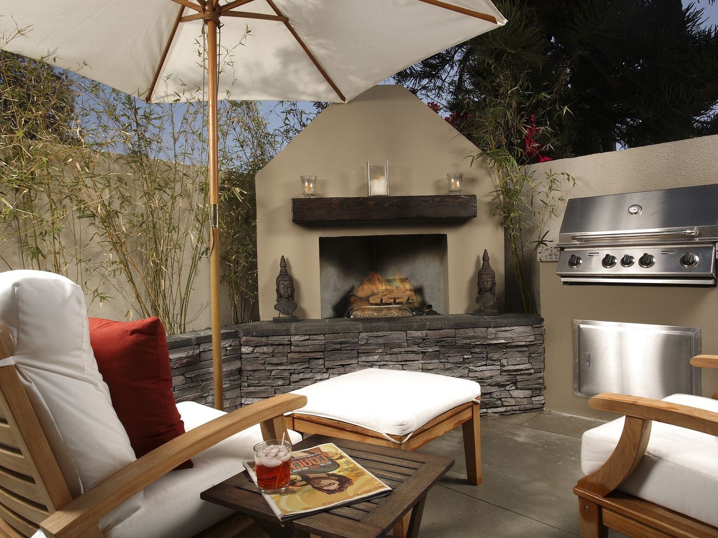 Outdoor fireplace with two chairs on a private patio