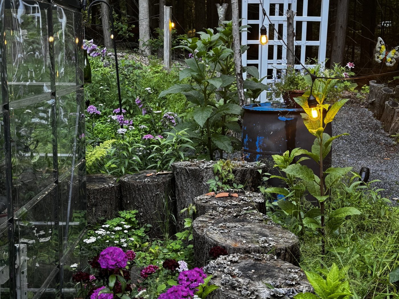 Stone wall with purple petunias and a glass-top bistro table